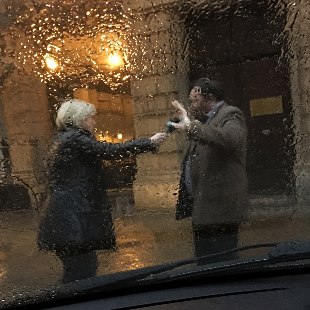 Entretien court au micro devant un porche, en soirée